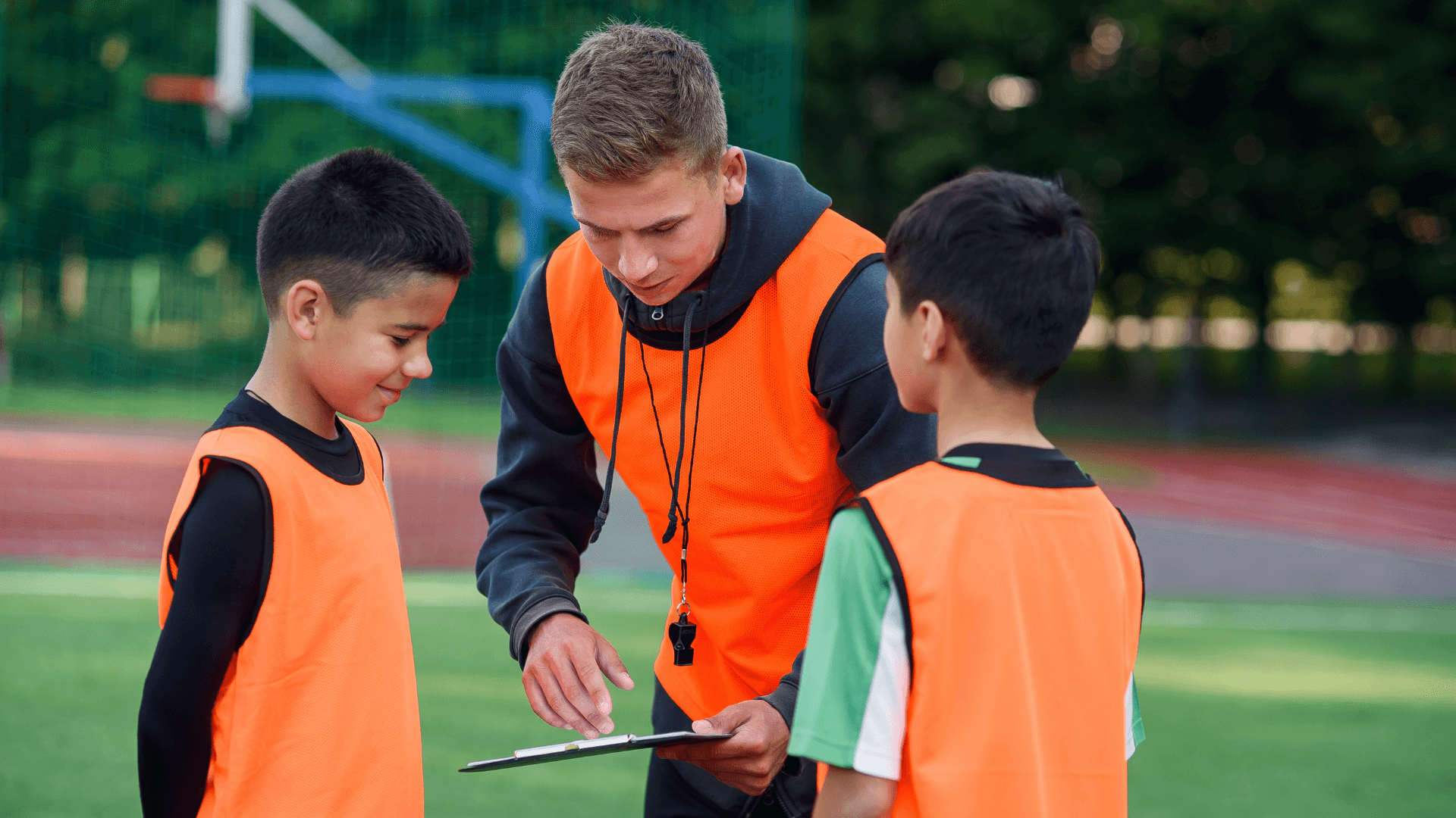 Coach working with young athletes on sports field